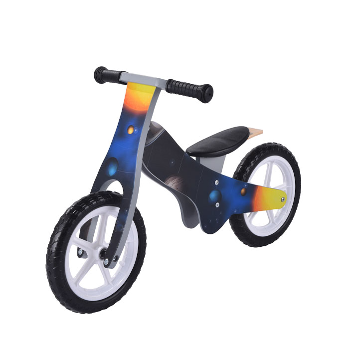A child navigating a small obstacle on a wooden balance bike, showing their developing coordination