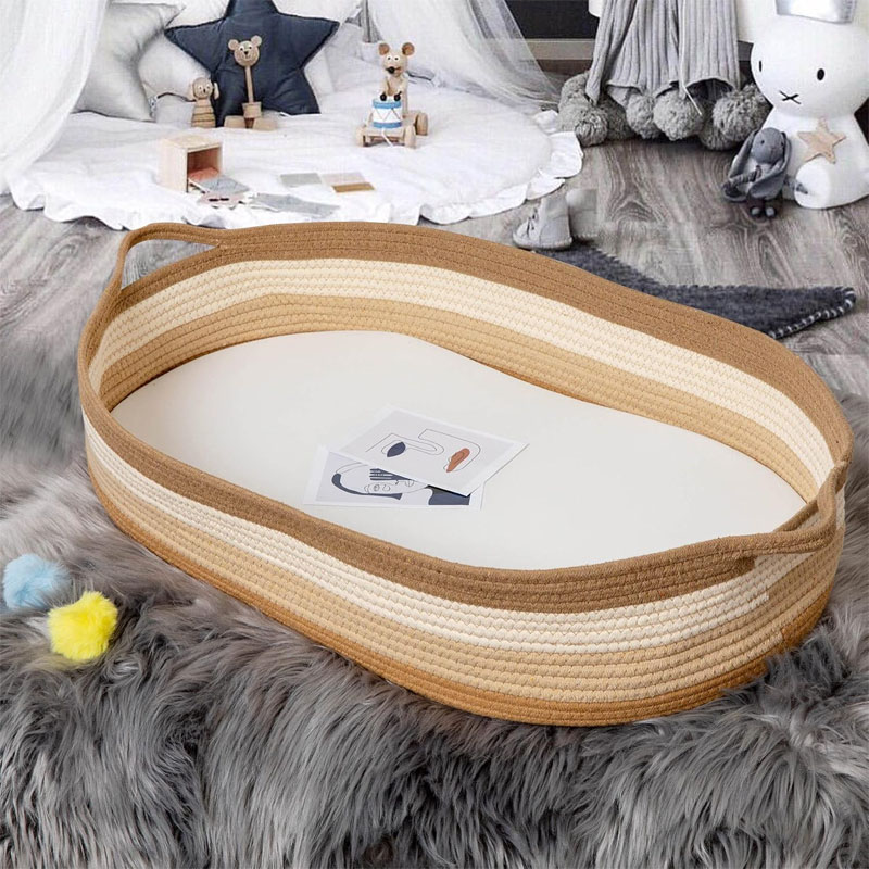 [A baby in a Moses basket, with arrows pointing towards a larger cot to show the transition