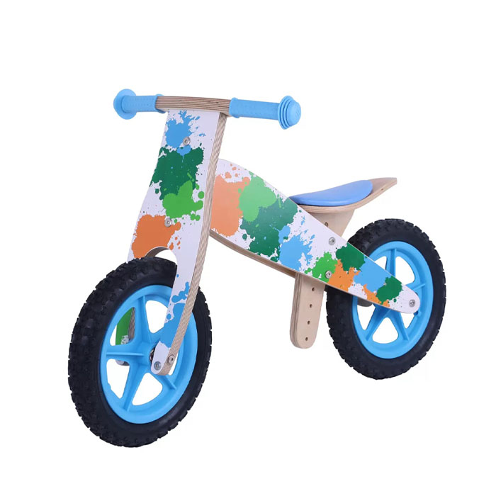 A happy child gliding confidently on a wooden balance bike in a park