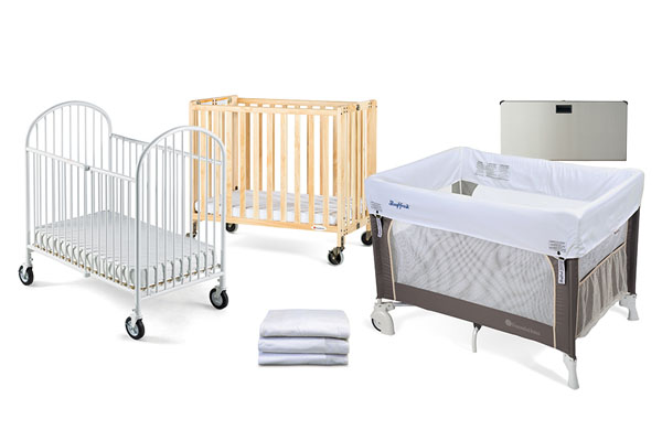 A clean, commercial-grade foldable crib set up in a hotel room