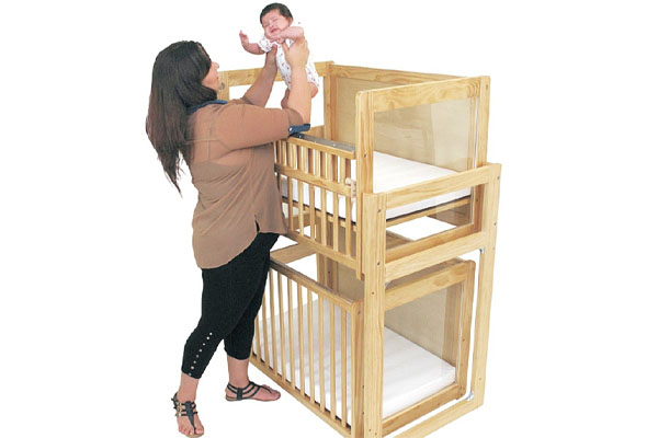 Two commercial-grade stackable cribs shown in a daycare setting